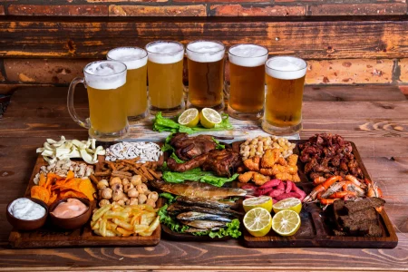 Variety of snacks and nuts with beer cups Variety of snacks and nuts with beer cups